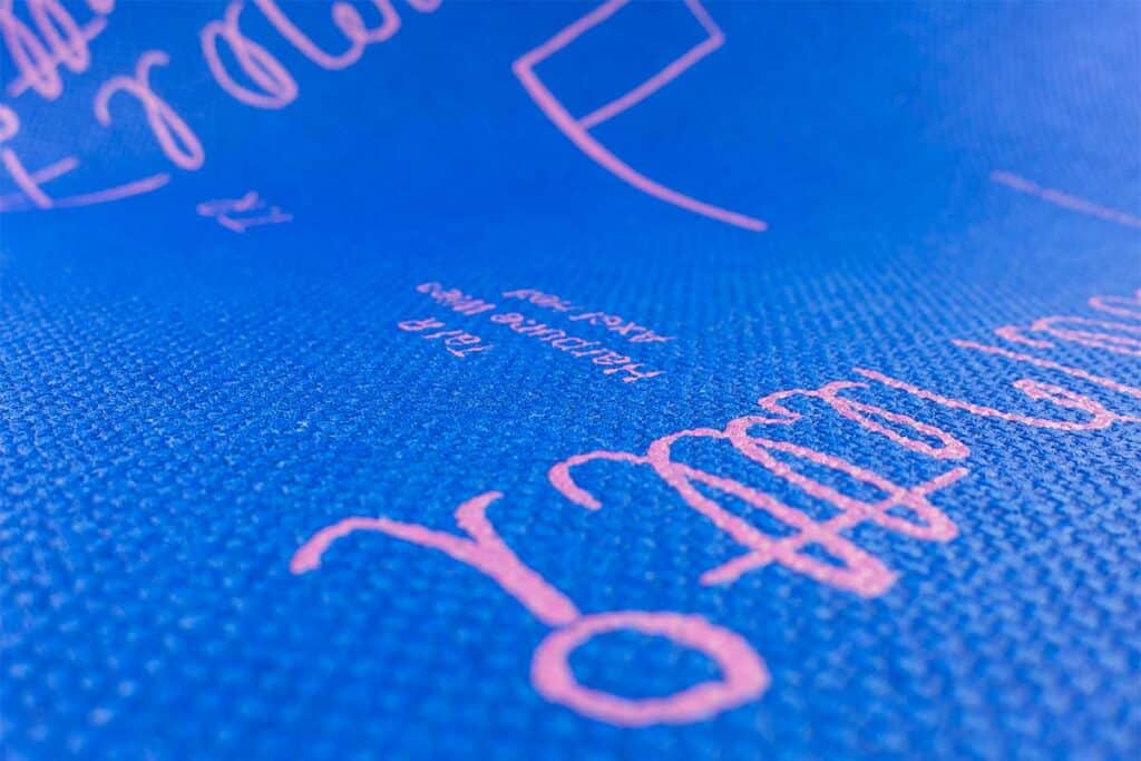 Kunstdruck, gedruckt auf einem sehr stark strukturiertem, blau durchgefärbtem Bucheinbandmaterial mit deutlichen Höhenunterschieden im Material