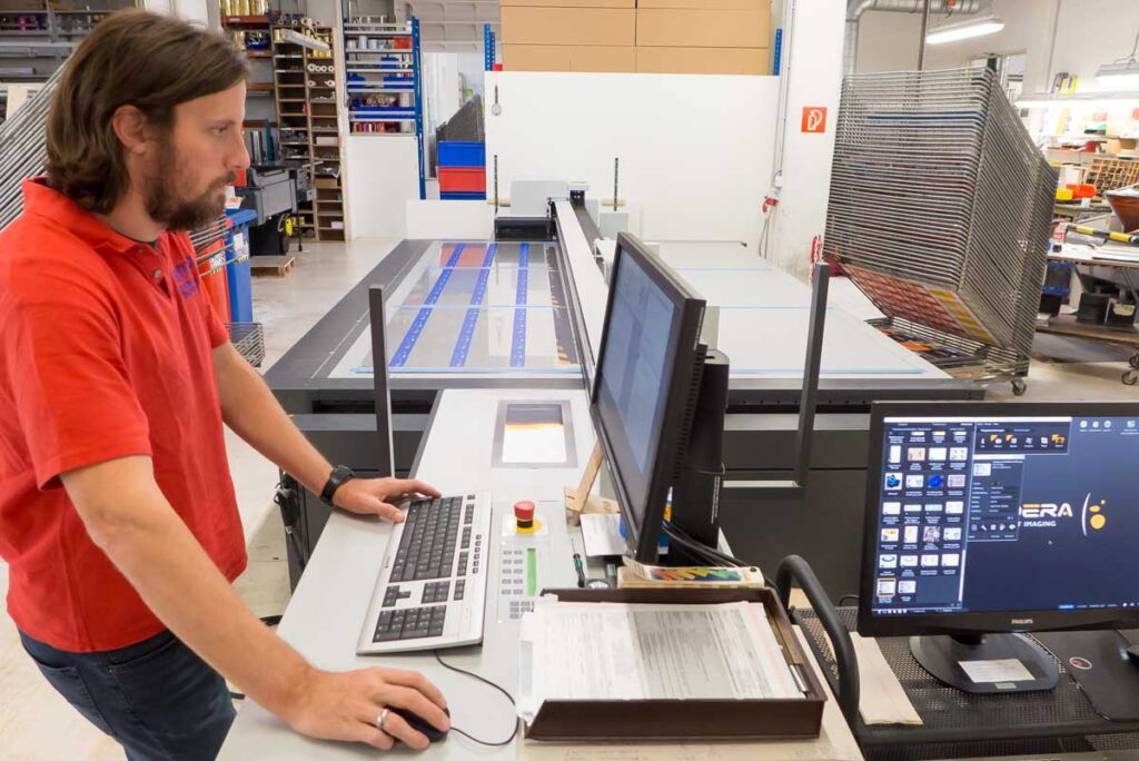 Operator / Maschinenführer an einer Großformat LFP UV-Inkjet Digitaldruckmaschine
