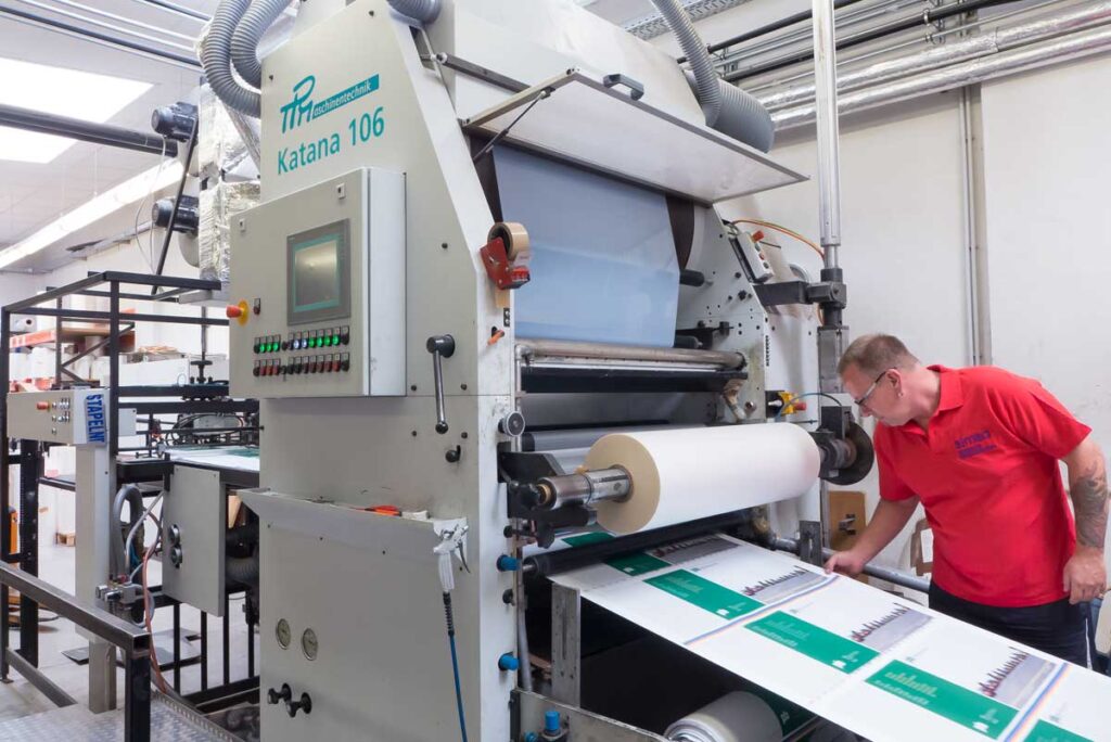 Maschinenführer an einer großformatigen Folienkaschiermaschine, Aufkaschierung von Mattfolie